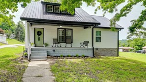 Ein eingeschossiges Haus mit Veranda, kleinem Vorgarten und einem Metall-Dach.