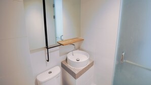 Ein Badezimmer mit Toilette, Waschbecken, Spiegel und Tür.