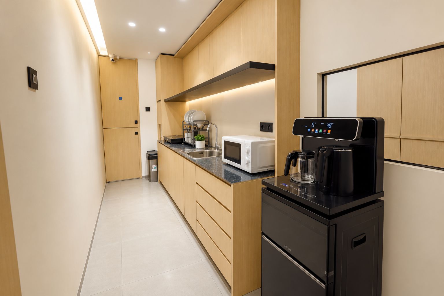 A modern kitchen with a microwave, coffee maker, and a sink.