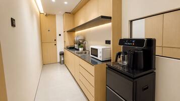 A modern kitchen with a microwave, coffee maker, and a sink.