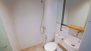 Ein kleines Badezimmer mit Toilette, Waschbecken und Dusche.