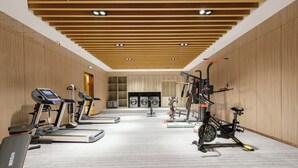 Una palestra con tapis roulant, cyclette e macchinari per pesi.