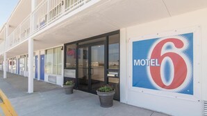 Et motel med et stort nummer seks-skilt, et overdækket gangareal og plantekasser.