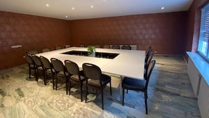 A conference room with a long table, chairs, and a plant. - Hotel Rheinstein (Ruedesheim am Rhein)