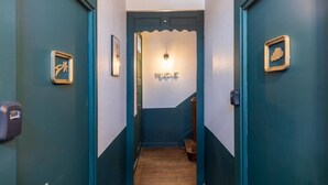 A hallway with teal walls, a welcome sign, and a door with a star-shaped lock. - Near City Center & Train Station - Saint-Brieuc (Saint-Brieuc)