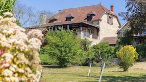 A stone house with a red-tiled roof, surrounded by greenery and a clear sky. - Holiday home in Rouffilhac with private pool (ROUFFILHAC)