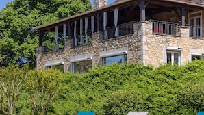 A stone building with balconies, a stone facade, and a lush green backdrop. - Holiday home in Rouffilhac with private pool (ROUFFILHAC)