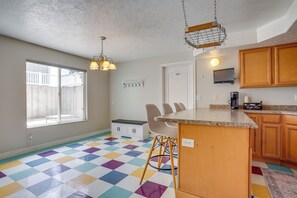 A kitchen with a checkered floor, wooden cabinets, a bar island, and a window with a view. - Easy AFB Commute! Clearfield Unit w/ Private Patio (Clearfield)