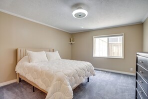 A bedroom with a bed, dresser, window, and ceiling light. - Easy AFB Commute! Clearfield Unit w/ Private Patio (Clearfield)