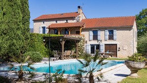 A stone house with a swimming pool, wooden deck, and a covered patio. - Holiday Home in Gramat near Padirac Cave (GRAMAT)