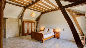 A bedroom with a wooden ceiling, a bed, a wardrobe, and a hanging light fixture. - Holiday Home in Gramat near Padirac Cave (GRAMAT)