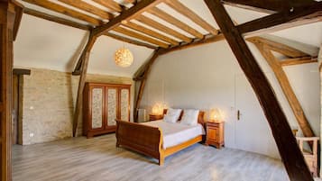 Une chambre avec un plafond en bois, un lit, une armoire et un luminaire suspendu.