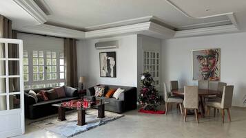 Un salon spacieux comprenant un canapé, une table basse et un coin repas avec des chaises.