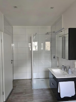 A modern bathroom with a shower, a sink, and a mirror. - Holiday Home 'Ritah' with Shared Terrace, Private Garden and Wi-Fi (Idar-Oberstein)