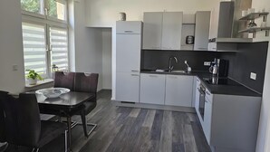 Una cucina moderna con zona pranzo, dotata di forno, lavello e macchina per il caffè.