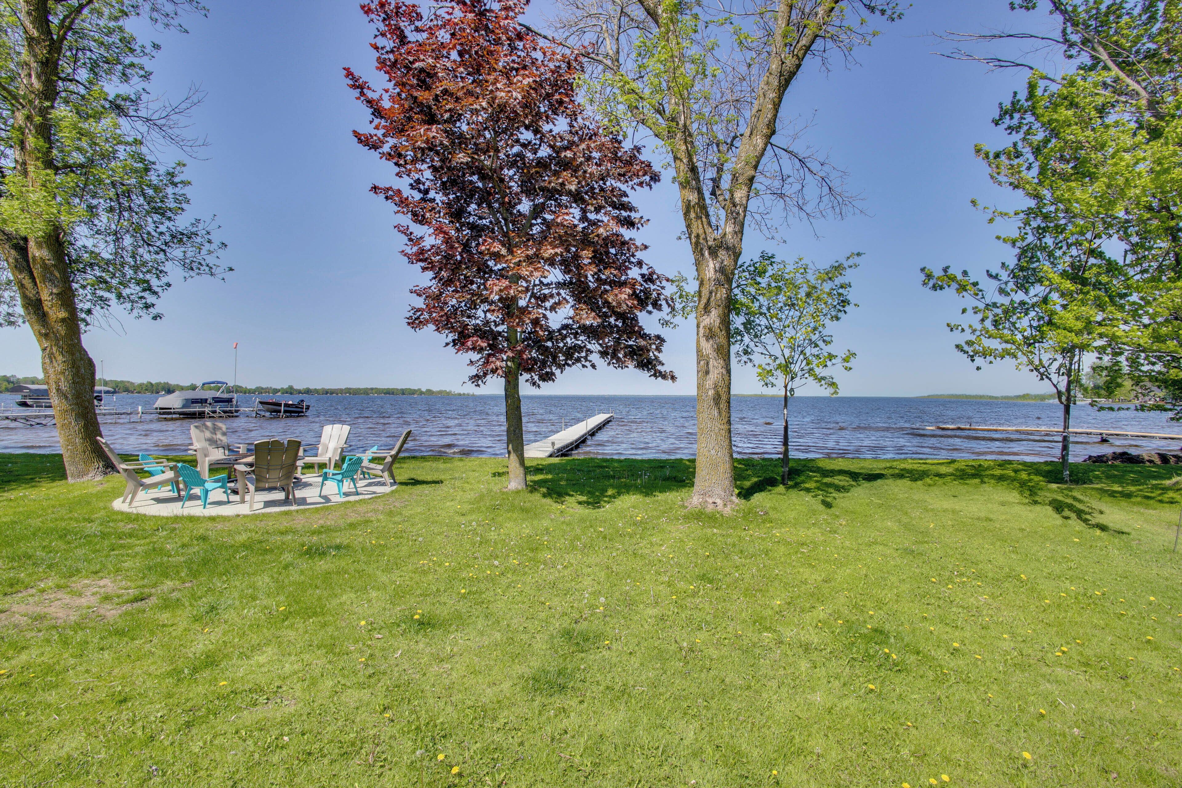 A grassy area with outdoor seating and a view of a lake.