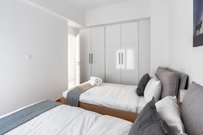 Ein Schlafzimmer mit zwei Betten, einem Kleiderschrank und einem Fenster.