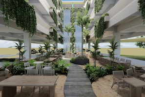 An indoor garden with a waterfall, seating areas, and a view of the landscape.