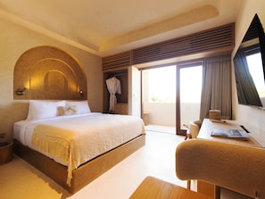 Habitación de hotel con cama, escritorio, bata y vistas al exterior.