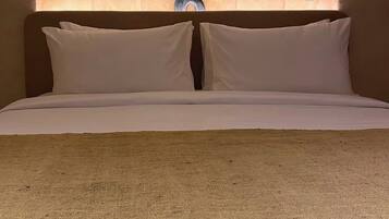 A bed with a headboard featuring an arched design and two wall-mounted light fixtures.