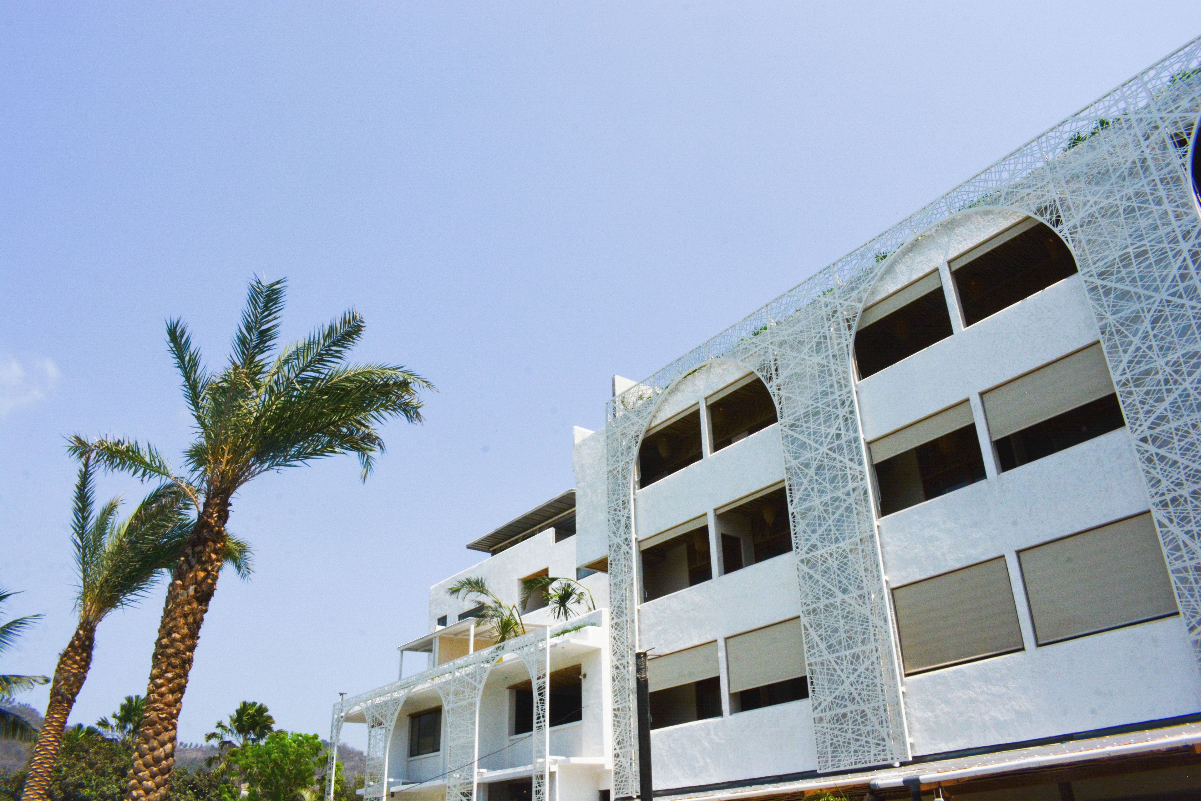 Un immeuble à plusieurs étages doté d’une architecture moderne, avec des balcons et de grandes fenêtres.