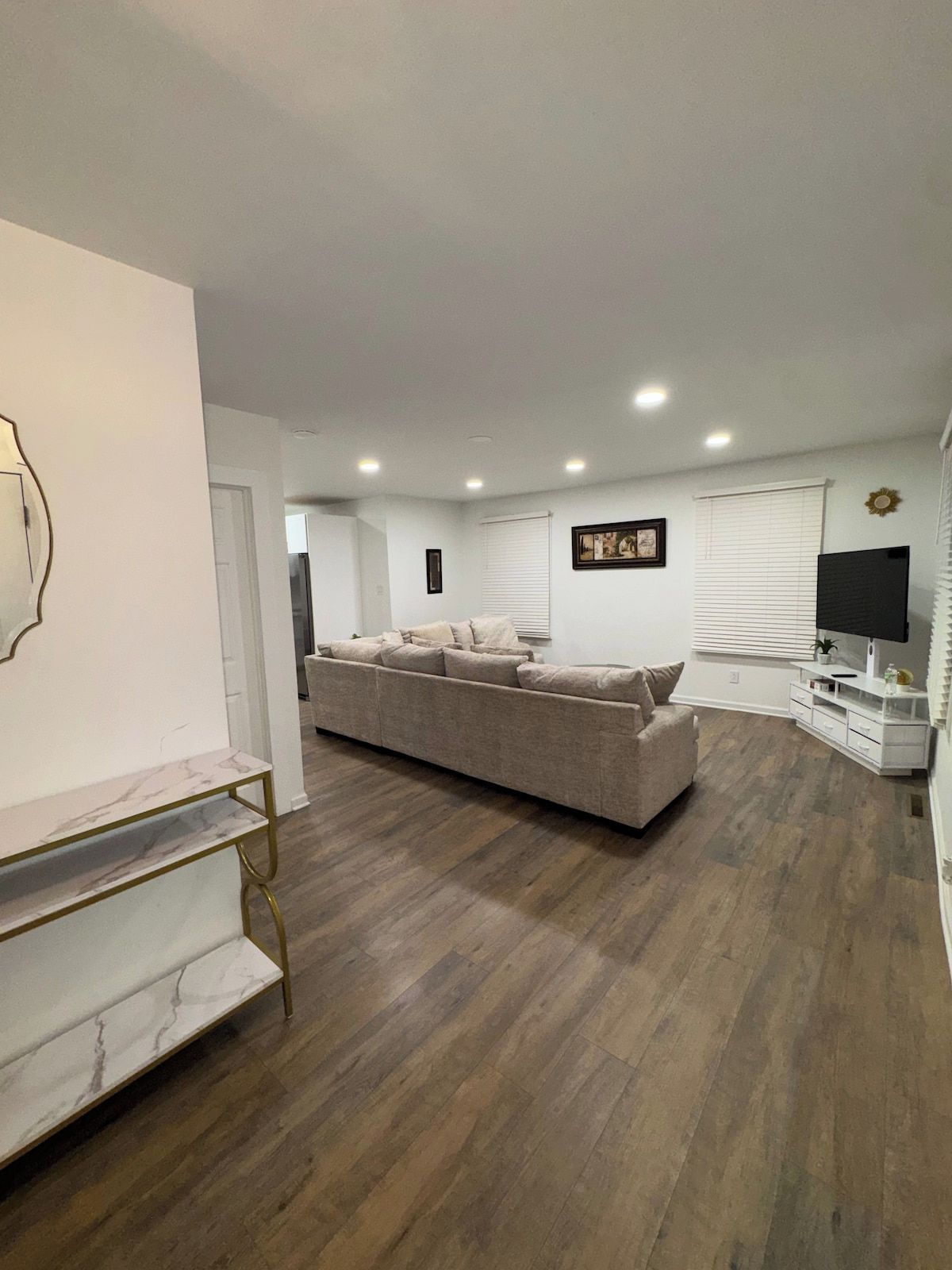 A living room with a sofa, a TV, and a marble shelf.