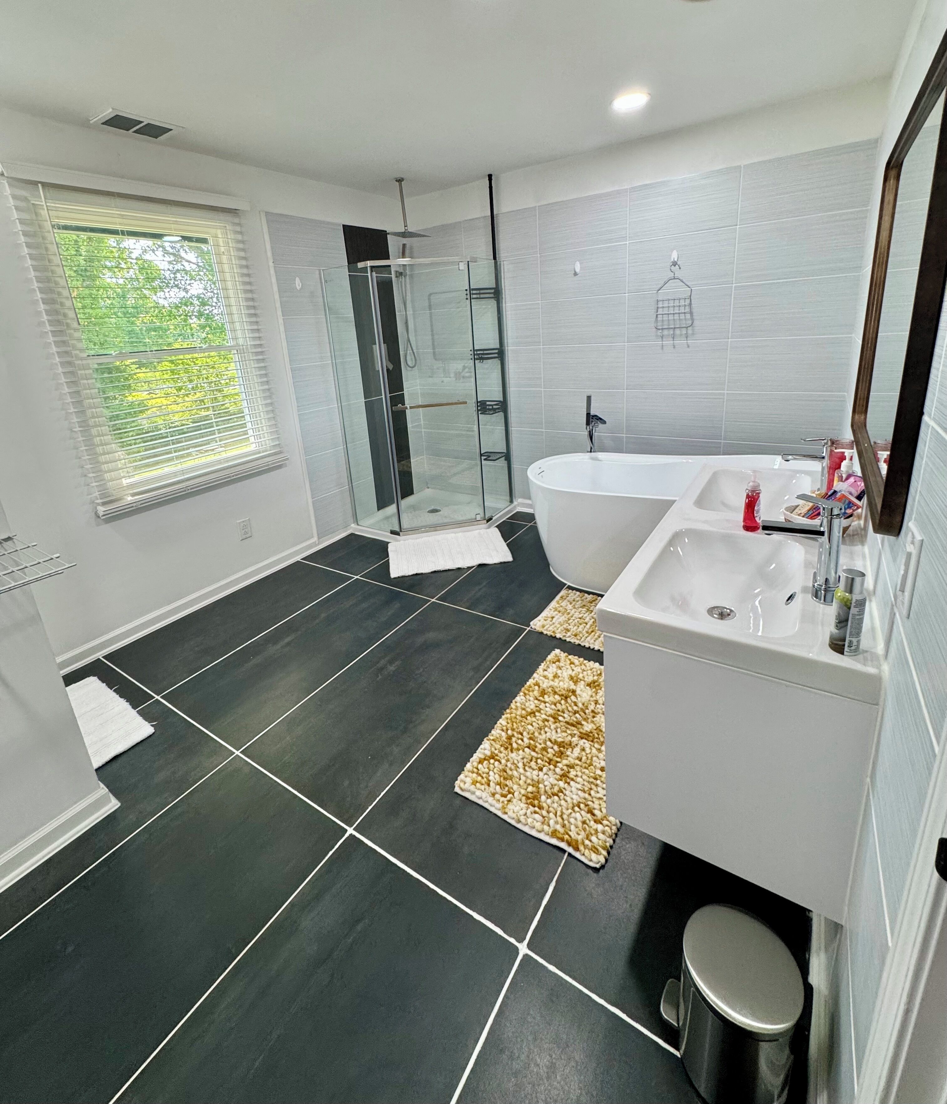 A modern bathroom with a glass shower enclosure, a freestanding bathtub, and a large mirror.. Premium Executive 4BR 3.5BA Home, Sleeps 9, Gastonia NC. 16 Min from CLT AirPort