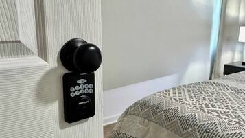 A room with a door equipped with a keypad lock and a round doorknob.