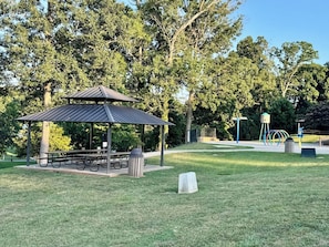 A park with a gazebo, picnic tables, and playground equipment.