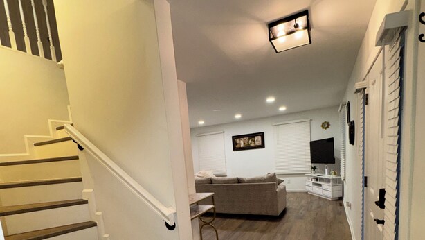 A staircase leading to a living area with a sofa, a TV, and a fireplace.