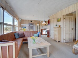A spacious living area with a sofa, a wooden coffee table, and a view of a kitchen and dining area. - "Solveig" - 1.5km from the sea by Interhome (Løkken)