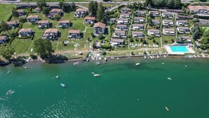 Ein Luftbild eines Wohngebiets mit Häusern, einem Schwimmbad und einem Steg mit Booten.