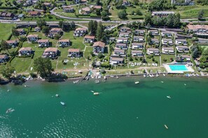 Ein Luftbild eines Wohngebiets mit Häusern, einem Schwimmbad und einem Steg mit Booten.