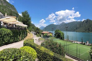 Ein Hotel am Berghang mit Außenbereich und Tennisplatz.