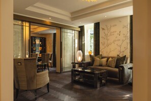 A modern living room with a sofa, armchairs, a coffee table, and a glass cabinet with decorative items. - Hotel Villa Florhof (Zürich)