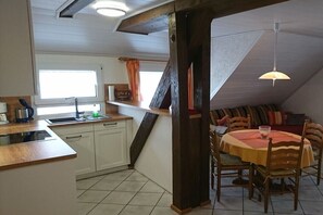 Eine Küche mit Spüle, Herd und Essbereich mit Stühlen und Tisch.