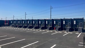 A row of portable restrooms with numbered doors, arranged in a parking lot with marked parking spaces. - HOTEL R9 The Yard Joso (Joso)