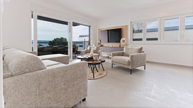 A modern living room with a sofa, armchairs, a coffee table, and a TV. - Crown Penthouse Čiovo (Okrug Gornji)
