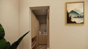 Ein schmales Dielenkorridor mit Holzboden, einem kleinen Teppich und einem Gemälde an der Wand.