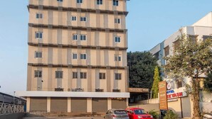 Ein mehrgeschossiges Hotel mit schlichter Fassade, zahlreichen Fenstern und einem Schild mit der Aufschrift 'Hotel Chee Yash'.