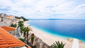 A coastal town with a beach, buildings with red-tiled roofs, and a clear view of the sea. - Villa Sunce Podgora -studio apartment 2 (Podgora)