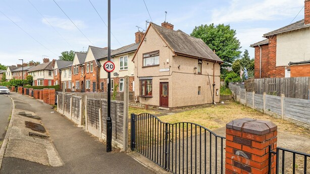 A residential street with houses, a speed limit sign, a black metal fence, and a brick wall. - 2 Bed House - Sleeps 4 - Parking - Wifi (Sheffield)