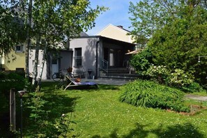 A modern house with a covered porch, a bicycle, and a well-maintained garden.