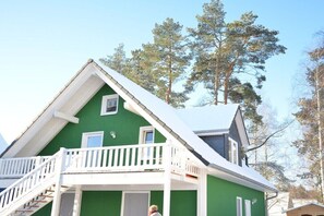 A green house with a white balcony and a small window. - Holiday apartment with 1 bedroom (Röbel\/Müritz)