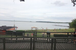 A waterfront view with a wooden deck, a gazebo, and a distant pier. - Holiday apartment with 1 bedroom (Röbel\/Müritz)