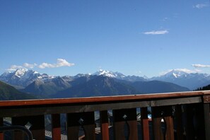 Blick auf Berge vom Balkon mit Holzwertung.