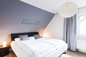 Ein modernes Schlafzimmer mit einem Bett, Nachttischen und einer Wandleuchte.