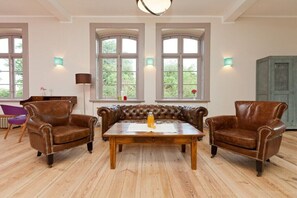 A room with a leather sofa set, a wooden coffee table, and two armchairs. - Rheinsberg in the Lexow Manor House (Walow OT Lexow)