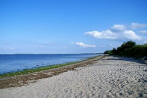 A beach with clear water, a sandy shore, and distant land. - Holiday apartment with 1 bedroom (Steinberg)