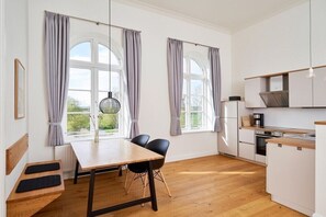 Eine moderne Küche mit weißen Schränken, einer Holz Arbeitsplatte und einem eingebauten Ofen.